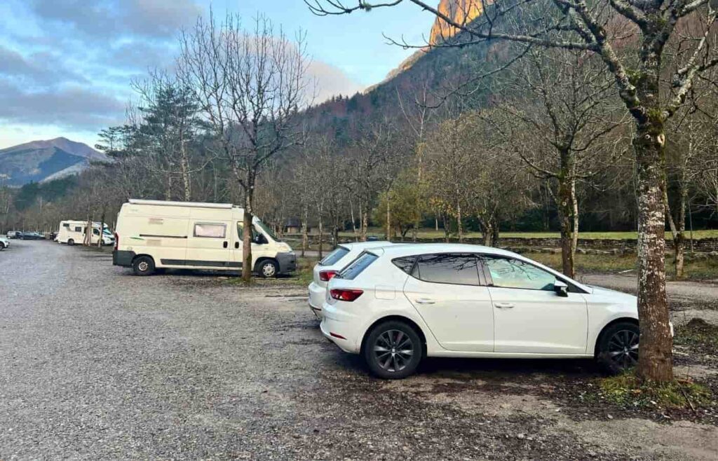 Zona de aparcamiento en la pradera de Ordesa con montañas de fondo.
