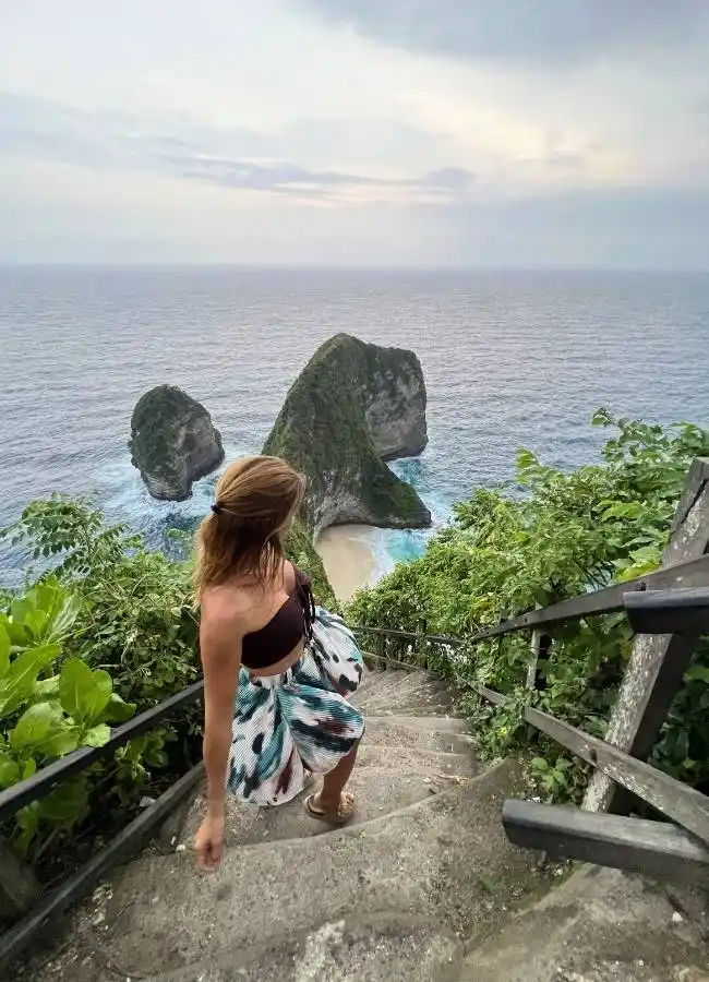 Viajera bajando por las escaleras del acantilado hacia Kelingking Beach.