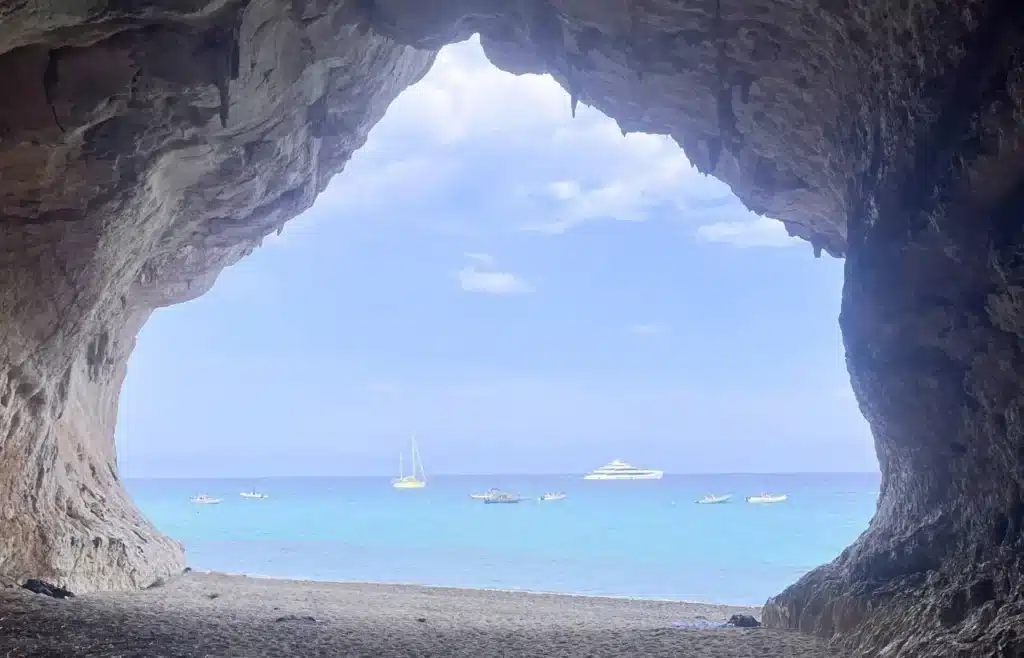 Vista del mar y los barcos desde el interior de las grandes cuevas de Cala Luna en el Golfo de Orosei.