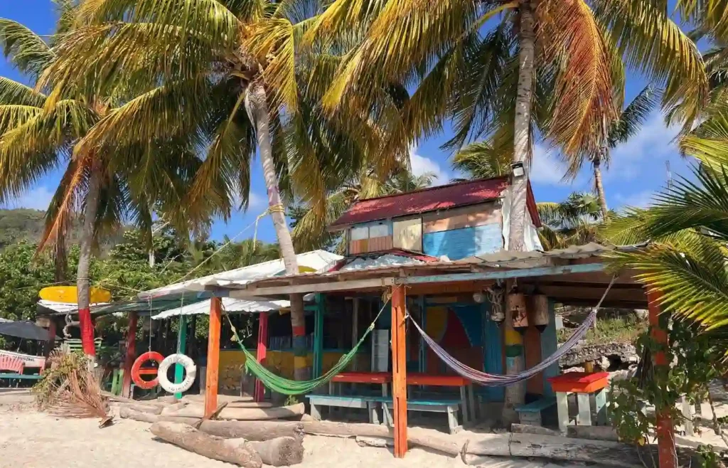 Chiringuito tropical vibrante en la playa bajo palmeras.