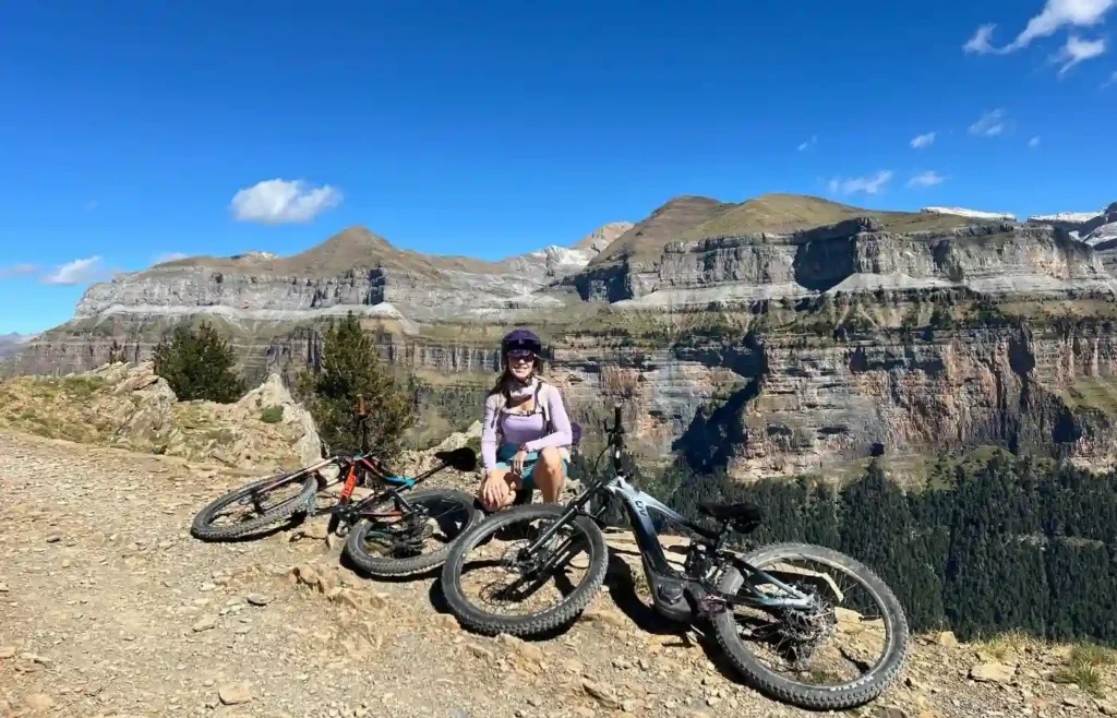 Mujer ciclista con e-bikes en impresionantes montañas, Pirineos.