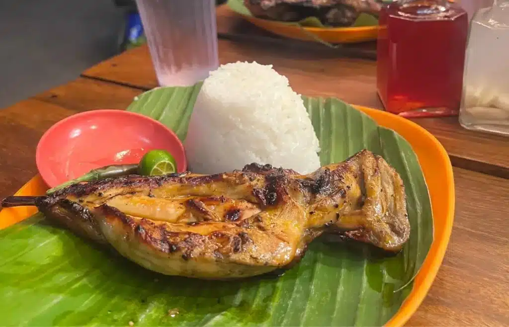 Plato de pollo asado con arroz blanco servido sobre una hoja de plátano en Filipinas.