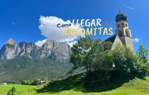 Iglesia tipica de los Alpes con letras de "como llegar a Dolomitas"