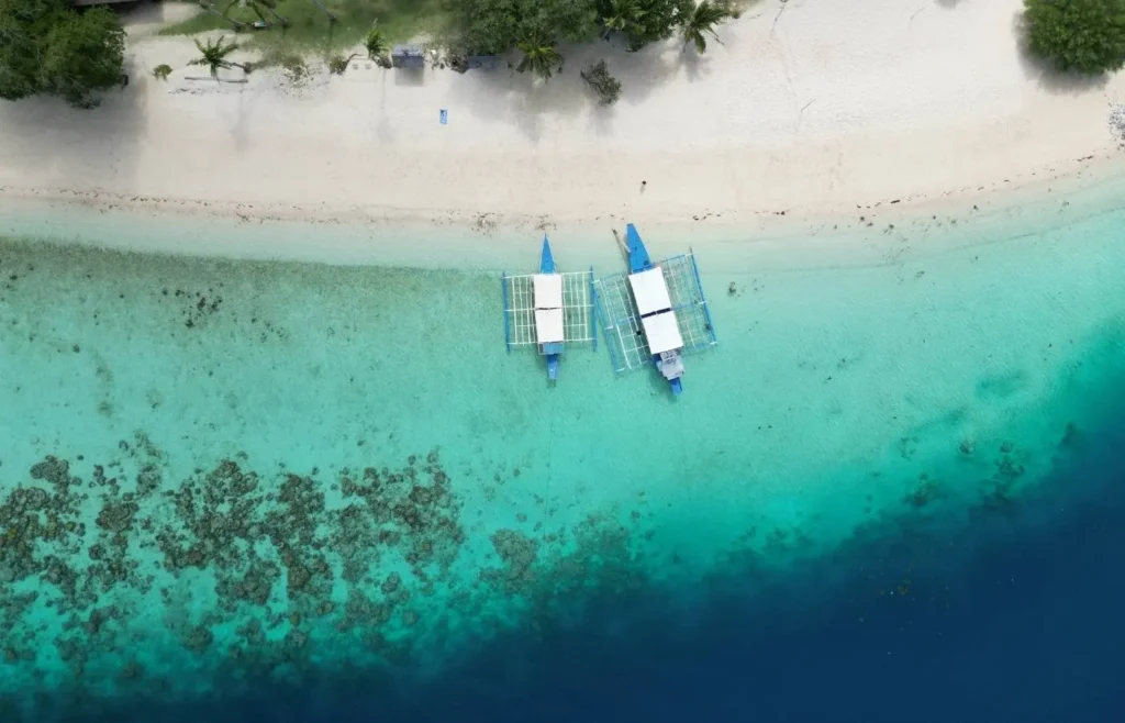 Vista aérea de barcos tradicionales bangka en aguas cristalinas de Filipinas.