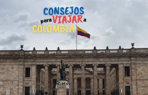 Bandera colombiana ondeando sobre un edificio histórico con estatua.