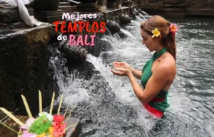 Mujer en templo de agua balinés, ritual con ofrendas.