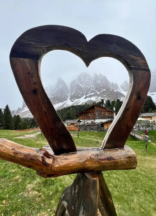 Corazón de madera en las Dolomitas con paisaje alpino.