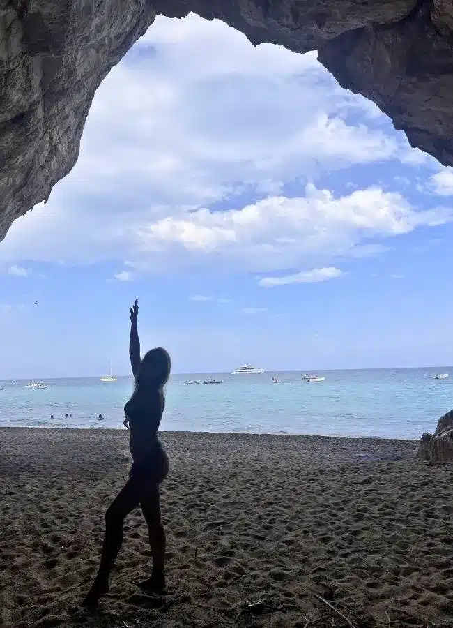 Silueta de Mireia en la entrada de las gigantescas cuevas naturales de Cala Luna en Cerdeña.