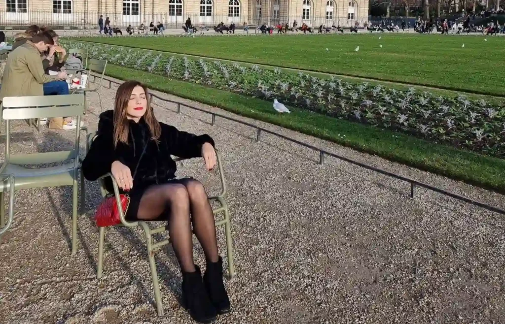 Mireia sentada en las icónicas sillas verdes de los Jardines de las Tullerías.
