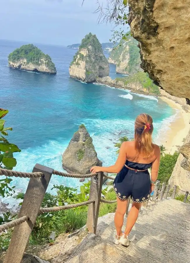 Chica posando en las famosas escaleras de roca con vistas a Diamond Beach.
