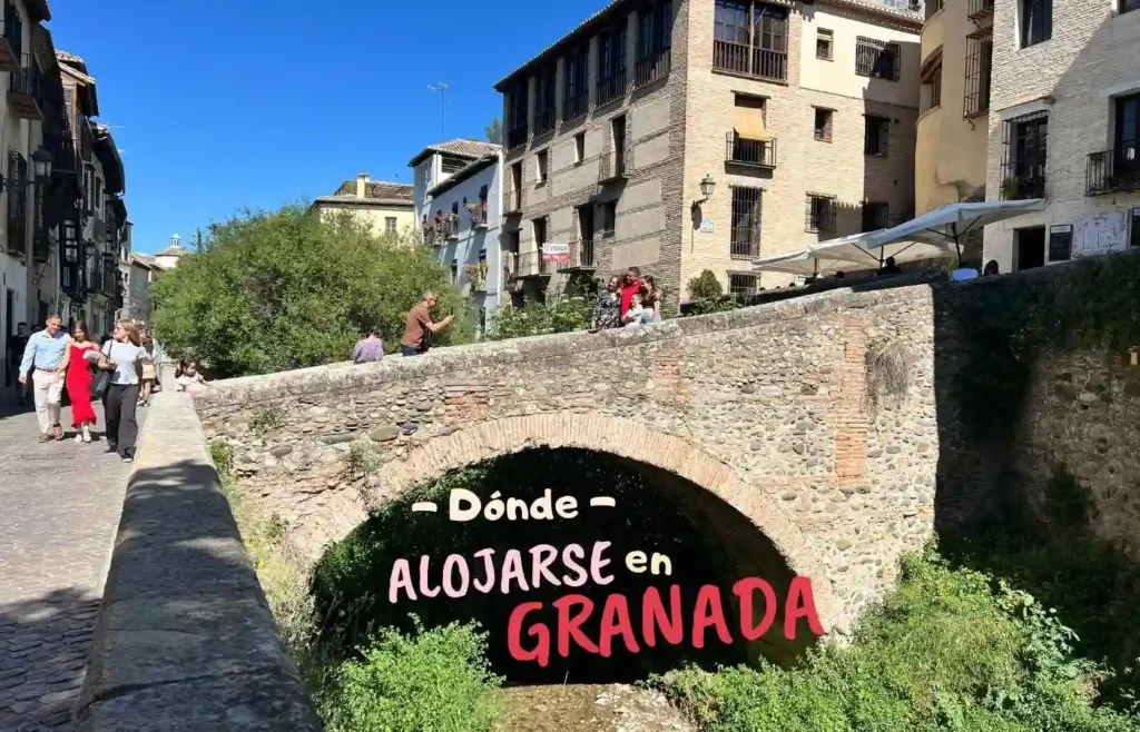 Imagen de portada de la sección "Dónde alojarse en Granada", mostrando un puente de piedra sobre el río Darro y edificios históricos del barrio del Realejo.
