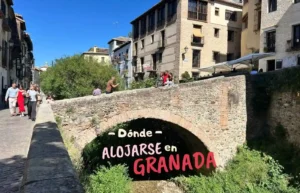 Imagen de portada de la sección "Dónde alojarse en Granada", mostrando un puente de piedra sobre el río Darro y edificios históricos del barrio del Realejo.