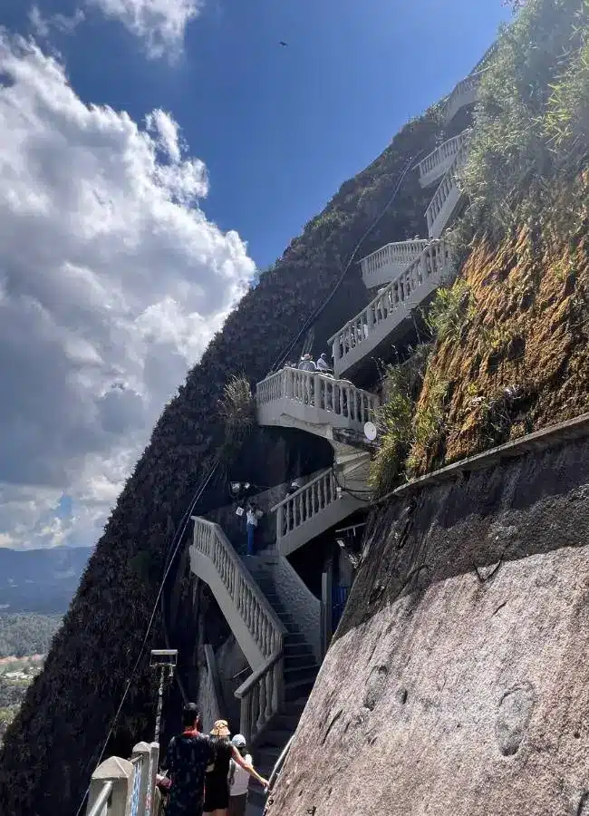 Empinadas escaleras zigzagueantes en la roca bajo cielo azul.