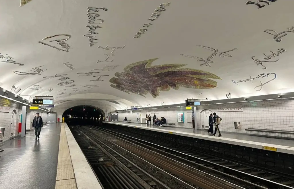 Interior de la estación de metro Abbesses decorada con arte en Montmartre.