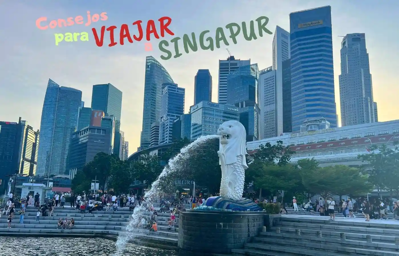 La icónica estatua del Merlion lanzando agua con los rascacielos de fondo.