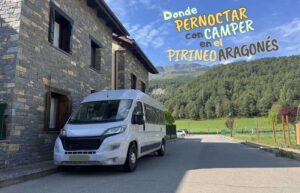 Furgoneta camper aparcada junto a una casa tradicional de piedra en Fiscal bajo un cielo azul.