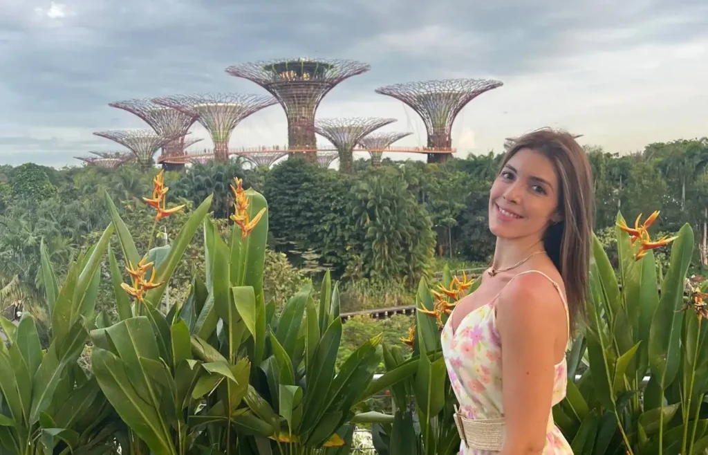 Mujer posando frente a los Supertrees en Gardens by the Bay durante el día.
