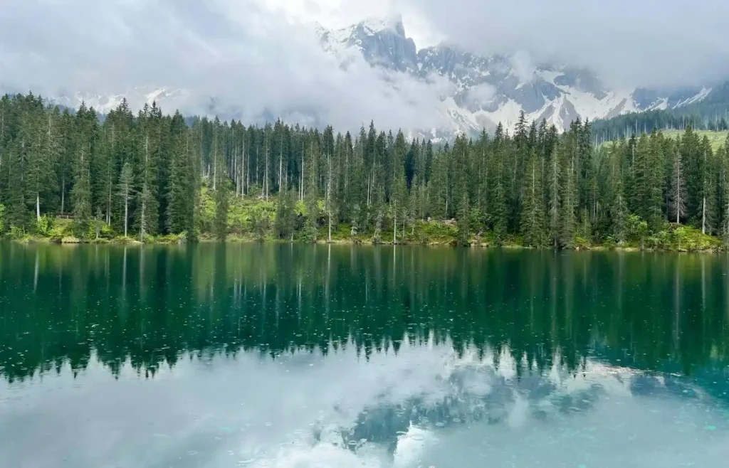El Lago de Carezza (Karersee) reflejando los pinos y las montañas en sus aguas verdes.
