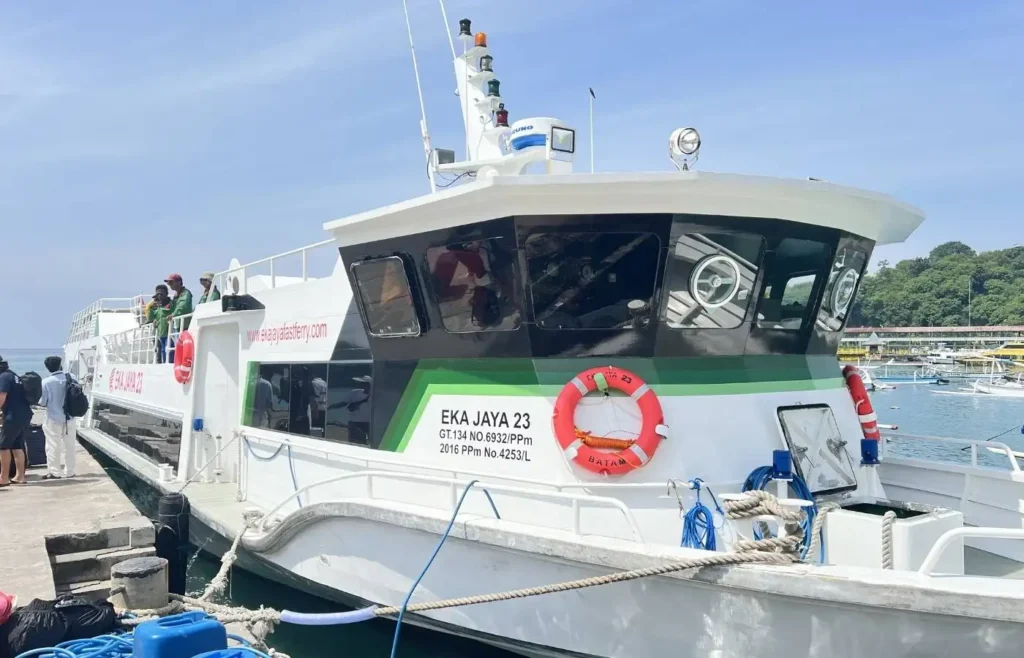 Ferry blanco y verde EKA JAYA 23 atracado en muelle.