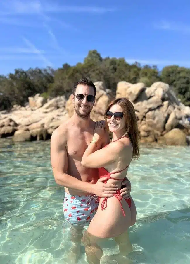 Héctor y Mireia bañándose juntos entre las rocas de una cala cristalina de Cerdeña.