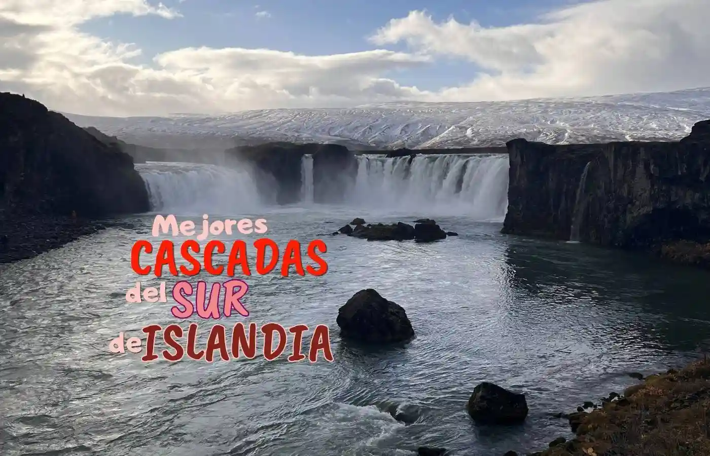 Impresionante cascada islandesa con montañas nevadas y río caudaloso.