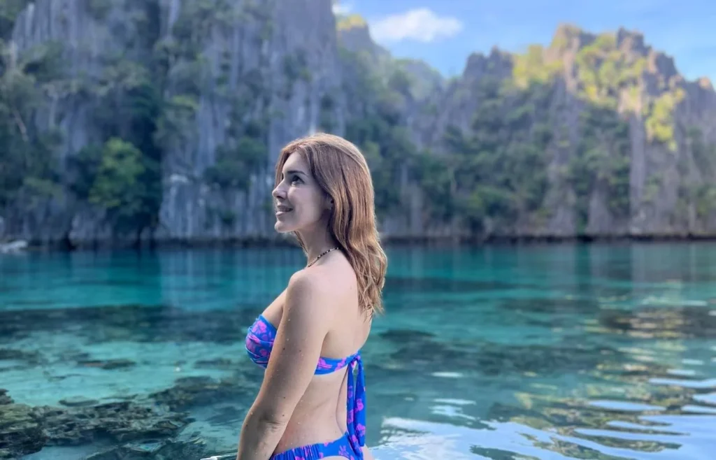 Mireia de espaldas mirando el agua cristalina de una laguna en Filipinas.
