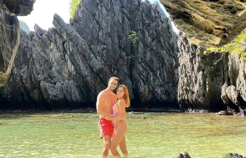 Pareja viajera explorando los paisajes de rocas y agua turquesa en Coron.