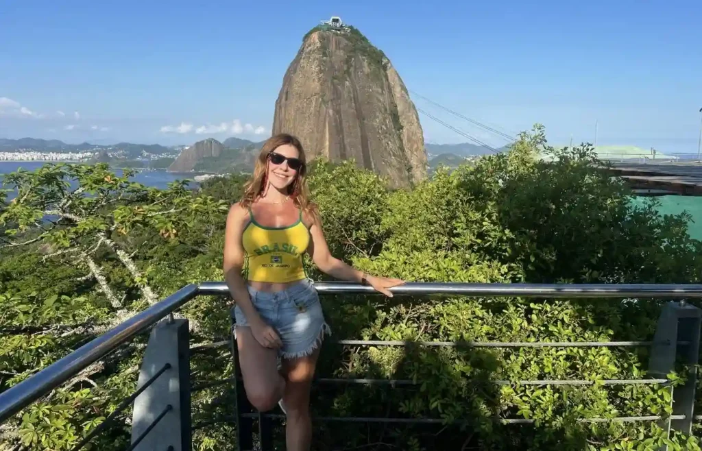 Mujer posando frente al icónico cerro Pan de Azúcar.
