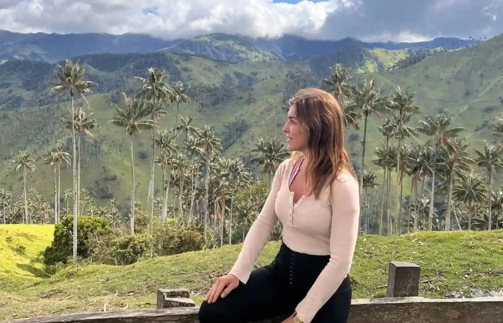 Viajera sentada contemplando la inmensidad del Valle de la Carbonera bajo un cielo con nubes.