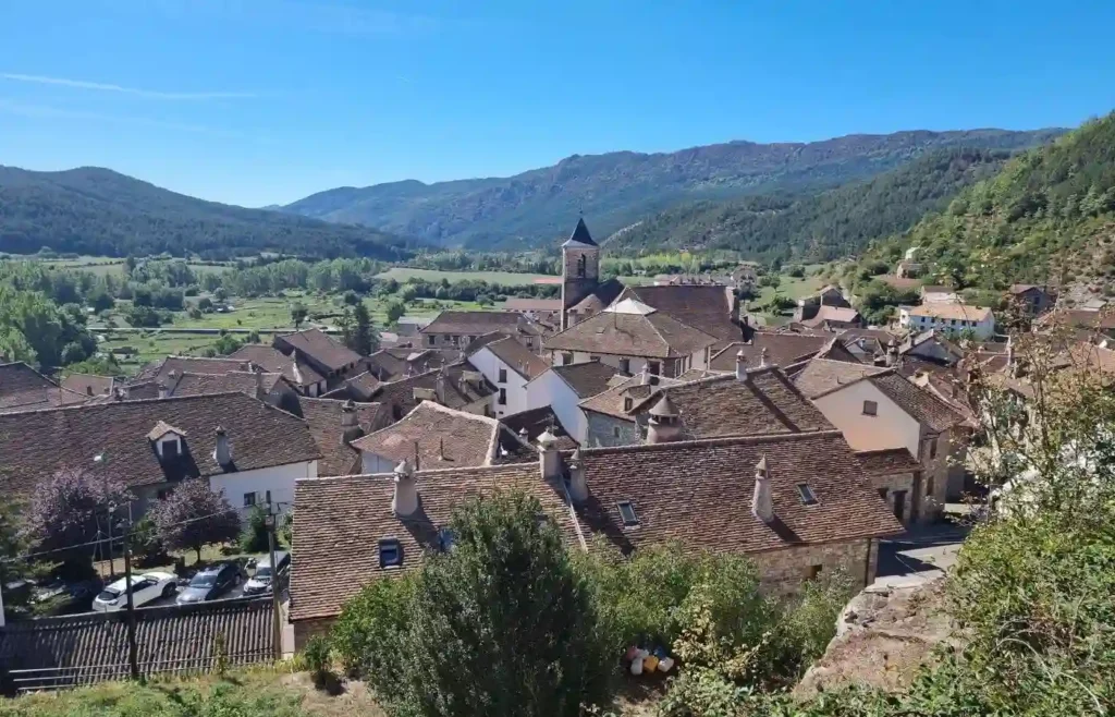 Vista de los tejados de teja y chimeneas tradicionales de Echo con el valle al fondo.