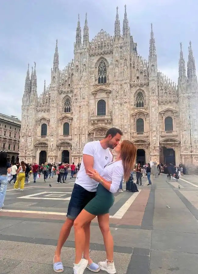 Pareja de viajeros en la Plaza del Duomo frente a la Catedral de Milán