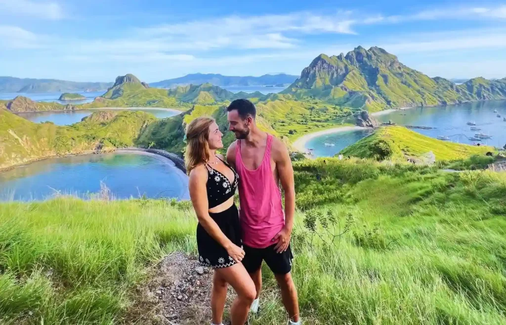 Pareja feliz en paisaje de islas verdes y mar azul.