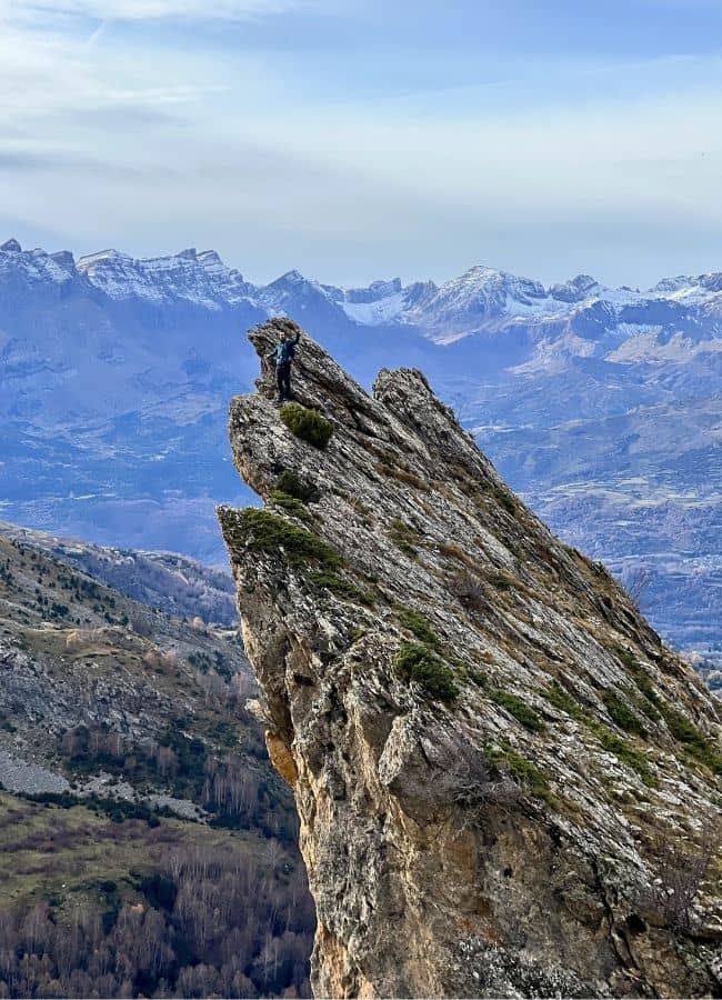 Impresionante formación rocosa puntiaguda (el "dedo" de Yenefrito) con las cumbres del Valle de Tena al fondo.