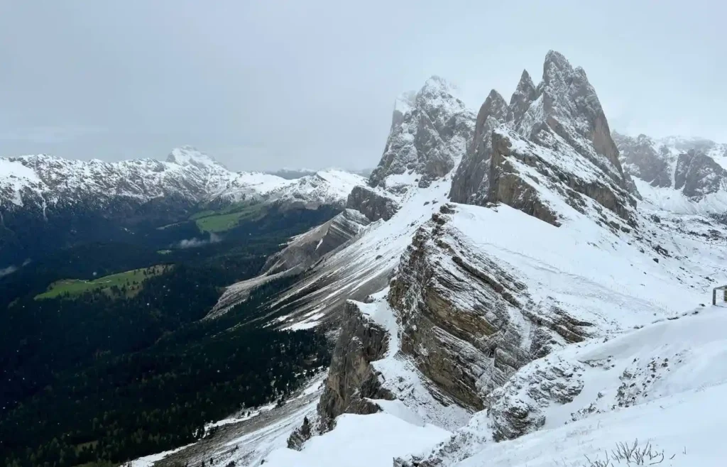 Los picos de Seceda cubiertos de nieve bajo un cielo nublado.