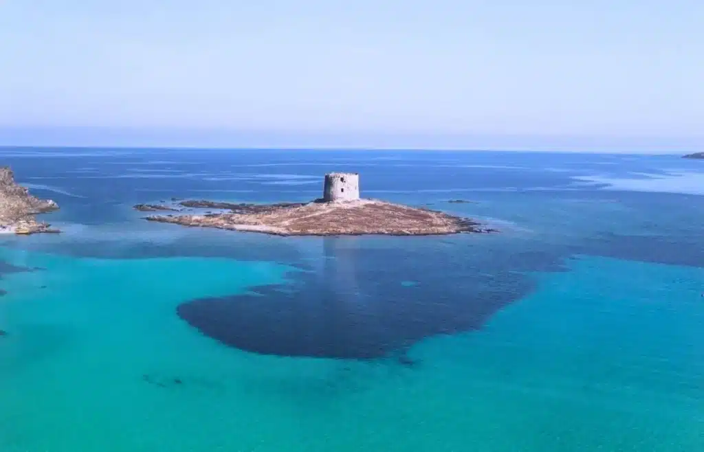 Vista aérea de la playa de La Pelosa en Stintino con su famosa torre aragonesa y aguas turquesas.