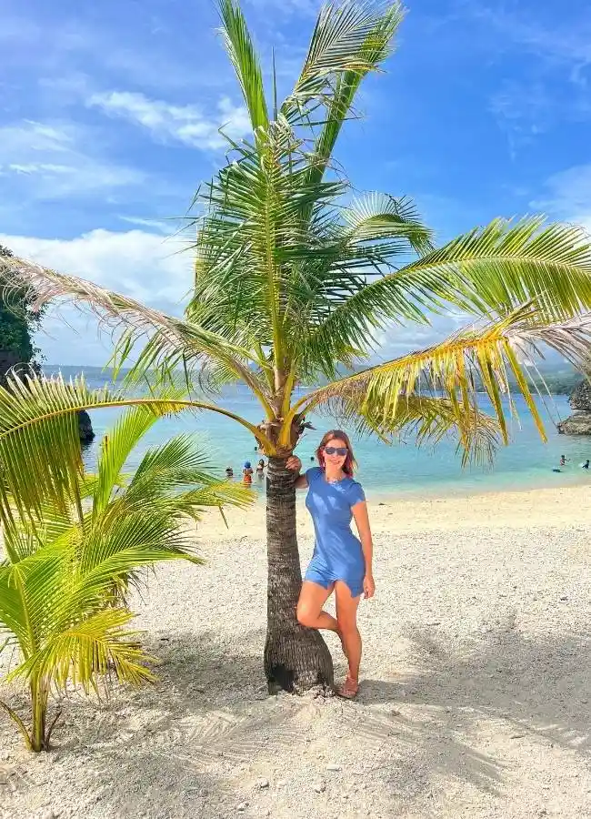 Mireia posando junto a una palmera en una playa virgen de Filipinas.