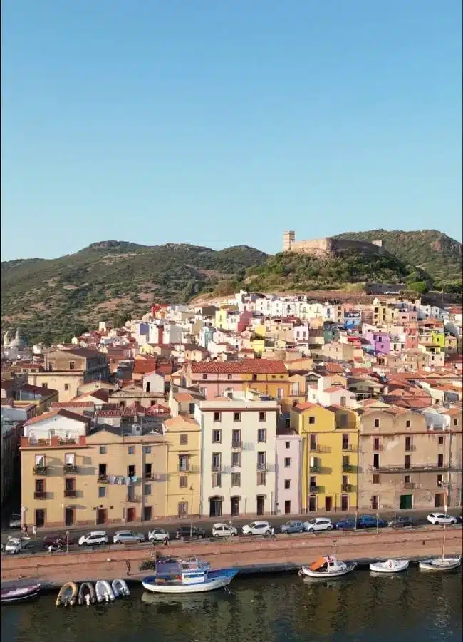 Panorámica aérea de las casas de colores de un pueblo histórico en la costa de Cerdeña.