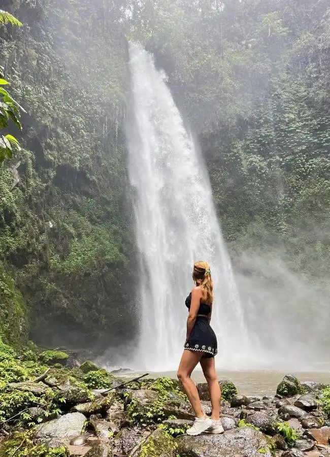 Viajera observando una gigantesca cascada de agua limpia en el norte de Bali.