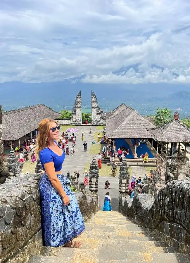 Mujer bajando las escaleras de piedra del templo Pura Lempuyang en el este de Bali.