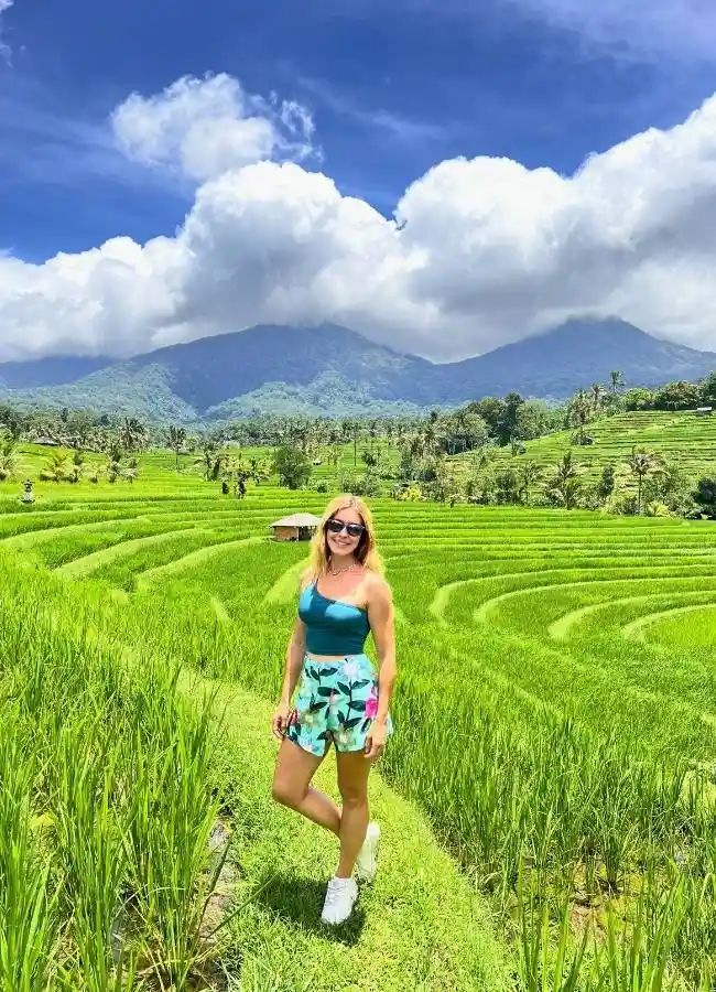Viajera paseando por los senderos verdes de las terrazas de arroz de Jatiluwih en Bali.
