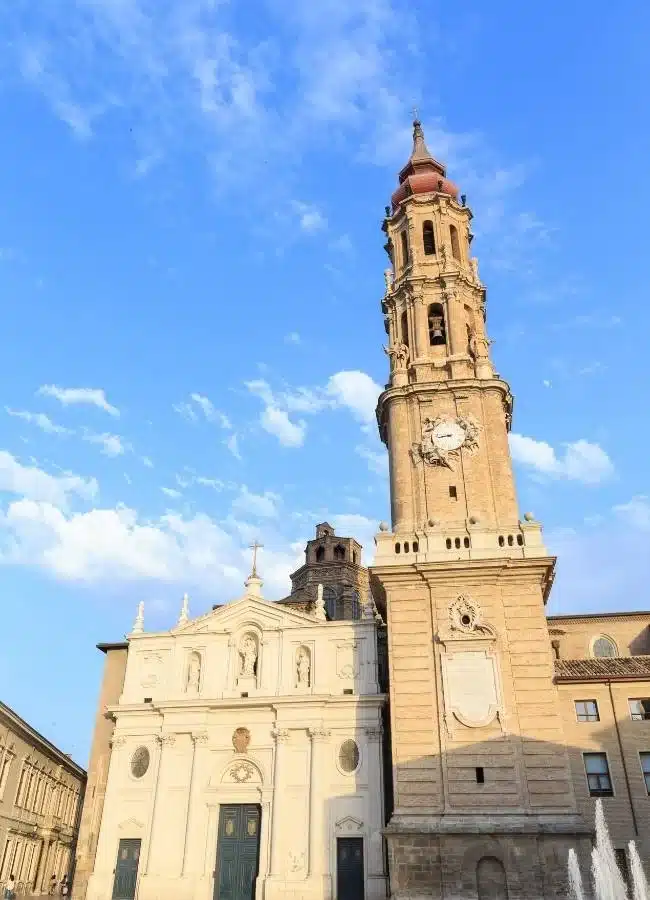 Imponente torre barroca del Pilar, Zaragoza, bajo cielo azul.