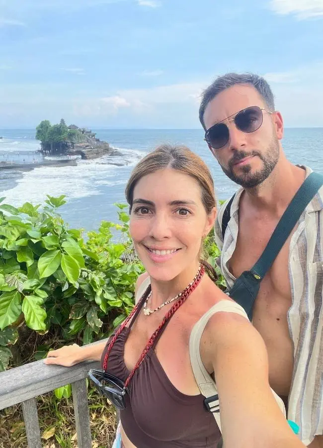 Pareja haciéndose una foto frente a la costa del templo del mar Tanah Lot en Bali.