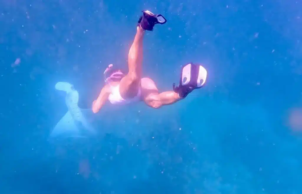 Viajero haciendo snorkel con aletas en las aguas transparentes de Komodo.