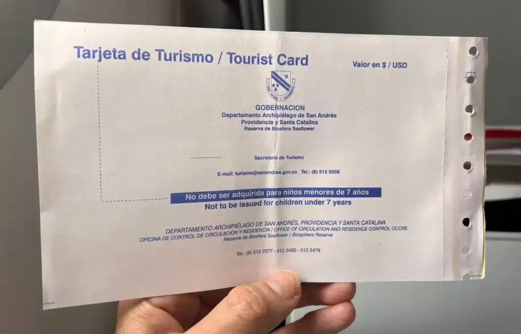 Tarjeta de turismo de San Andrés y Providencia en mano.