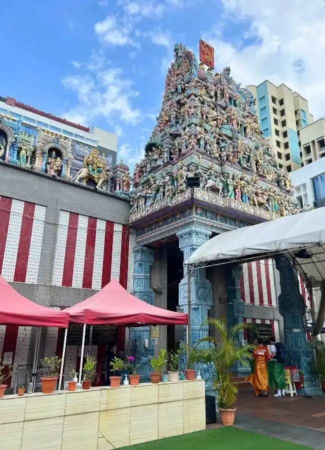 Templo hindú colorido con esculturas detalladas bajo cielo azul.