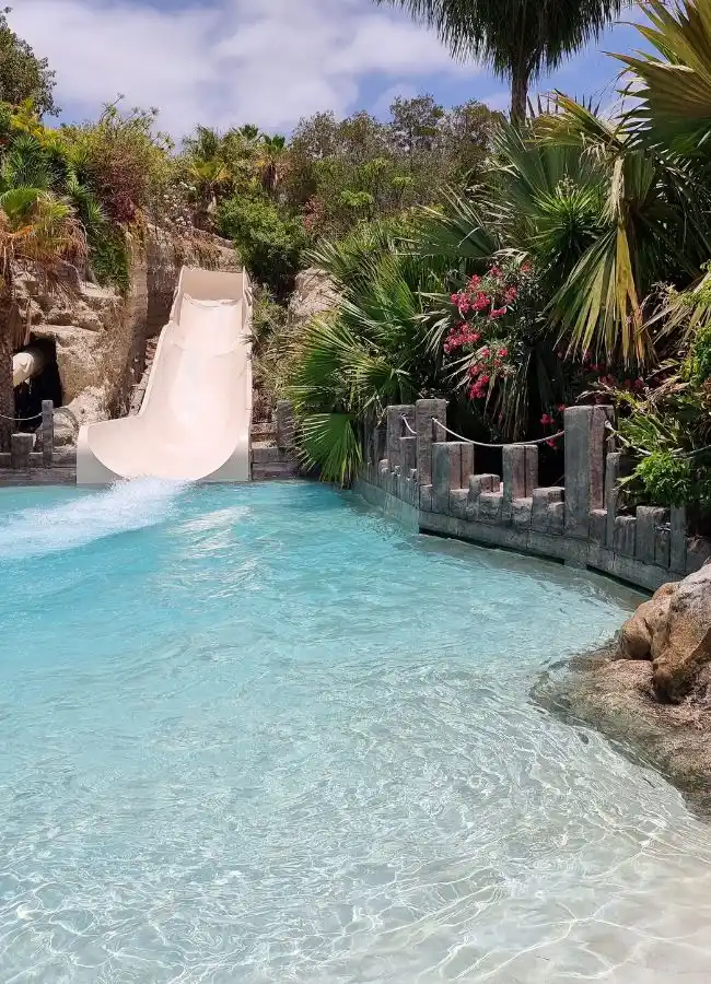 Tobogán de agua rodeado de vegetación tropical en el parque Siam Park de Tenerife.