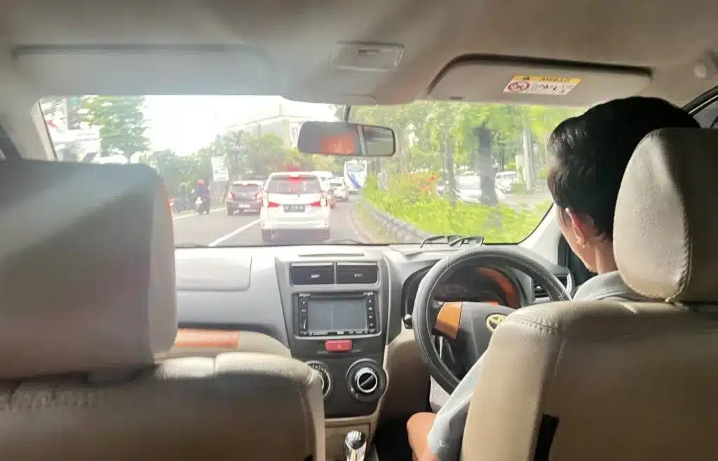 Trayecto en coche privado de Grab por las carreteras de Bali.