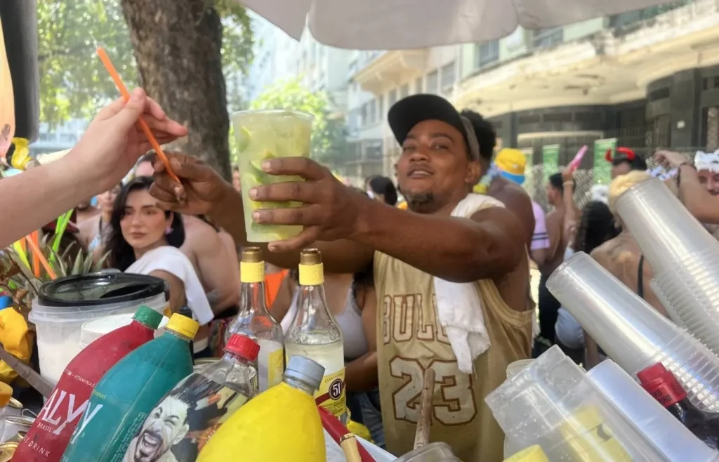 Un vendedor local preparando bebidas frescas para turistas en un puesto callejero.