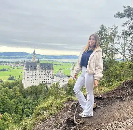 Viajera contemplando el Castillo de Neuschwanstein en Baviera, Alemania, desde un mirador elevado.