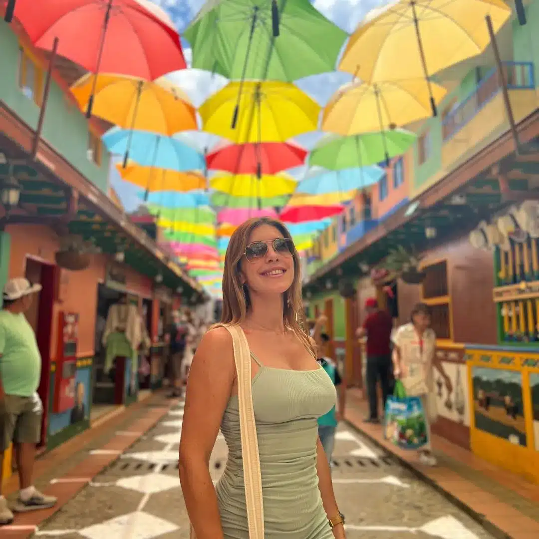 Viajera caminando por la colorida calle de las sombrillas en Guatapé, Antioquia, Colombia.